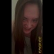 Emi squats on the toilet in a grey tank top on her period, shows her tampon, rubs herself as she poops into the bowl, then leans in close to the camera and smiles. Vertical format video. Over 8 minutes.